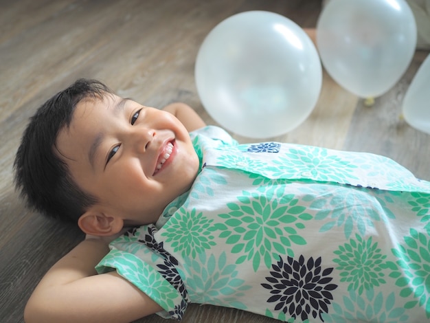 Happy little boy lying down on the floor and smiling