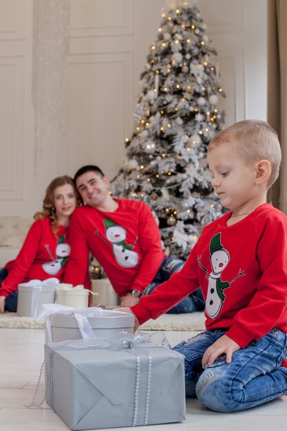 写真 新年の近くにクリスマスプレゼントを開く幸せな男の子