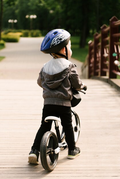 Ragazzino felice che guida una bici nel parco