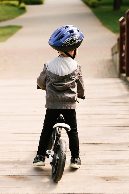 公園で走っている自転車に乗って幸せな少年