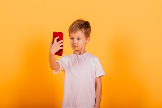 Happy little boy standing and talking on mobile phone   in studio