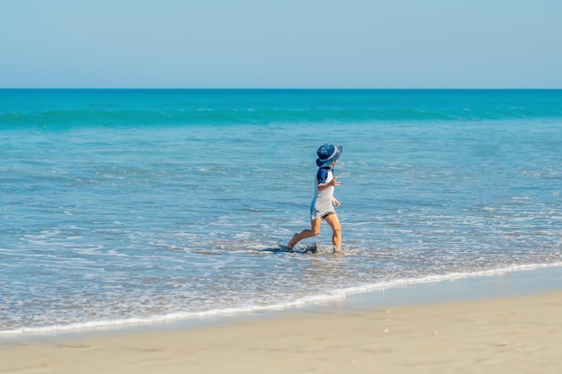 Happy little boy swimming on tropical beach