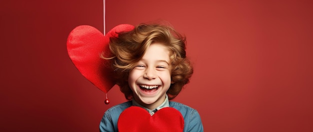 バレンタインデーに赤い心を持つ幸せな小さな男の子