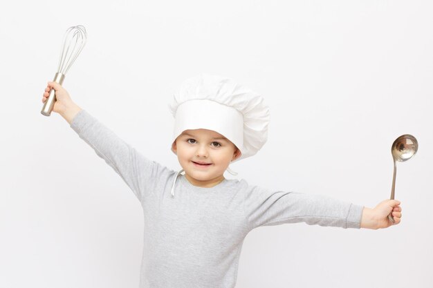 Photo happy little chef with a whisk, on white background.