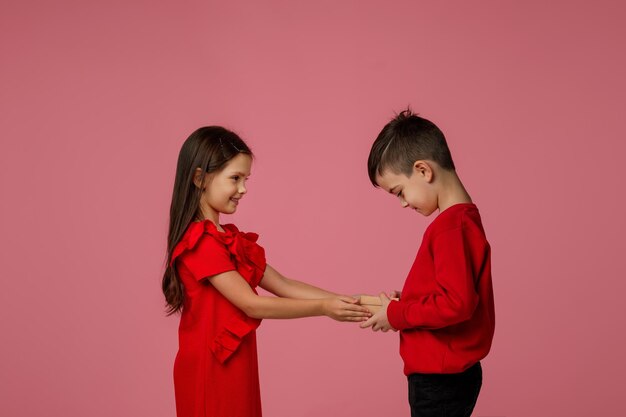 Happy little child boy gives smiling girl a gift box