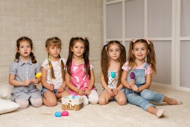 Happy little child girls with basket with painted easter