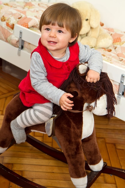 Foto piccolo bambino felice e un cavallo a dondolo.