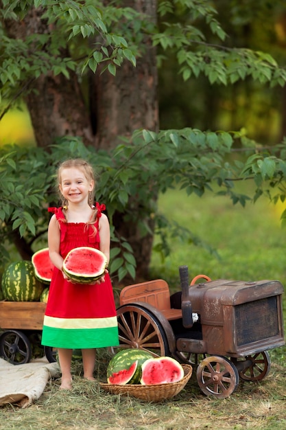 Happy little child surrounded by watermelons