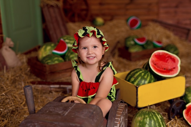 Happy little child surrounded by watermelons