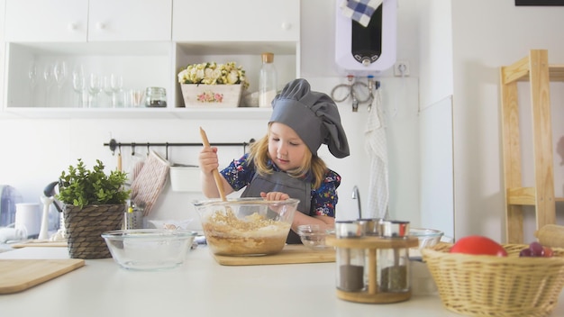 Happy little girl baker going to bake cookies in the kitchen  close up