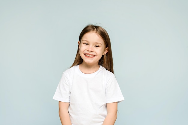 Happy little girl on blue background with copy space