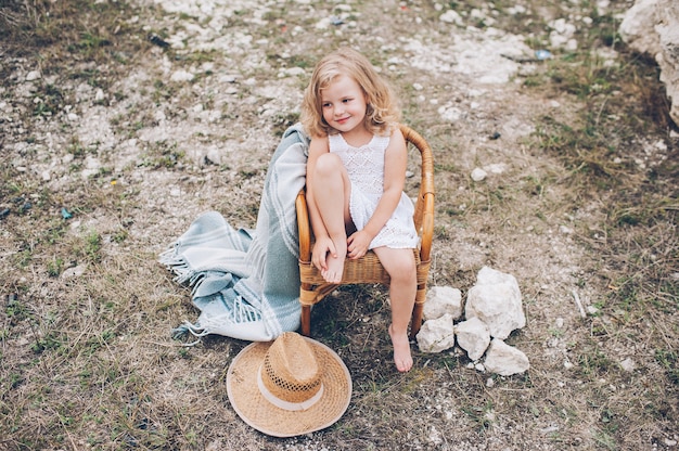 happy little girl in a chair outdoors