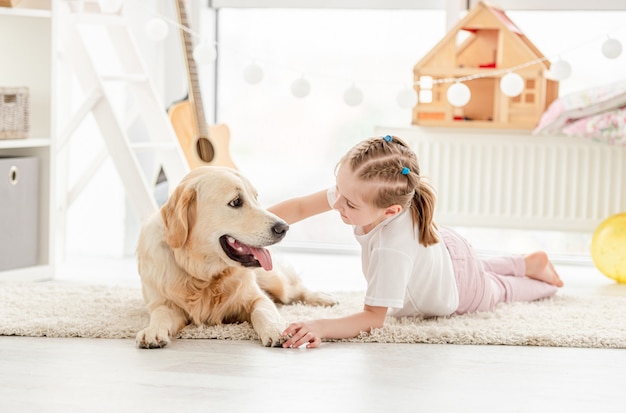 Happy little girl cuddling beautiful dog