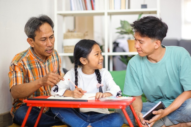 Happy Little Girl Doing Homework With Brother And Father Asian Family Concept