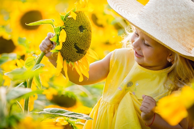 Foto bambina felice sul campo di girasoli in estate. bella bambina in girasoli