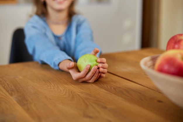 Happy little girl hold the pear in the hand