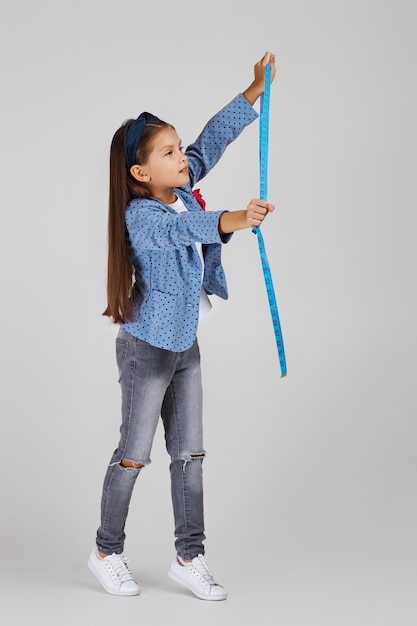 Happy little girl holding tape measure