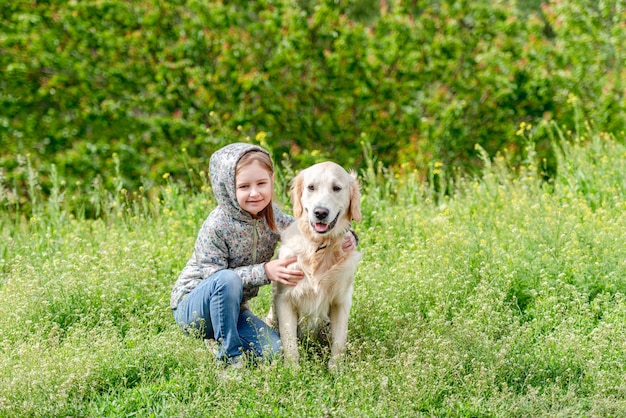 Bambina felice che abbraccia cane sveglio