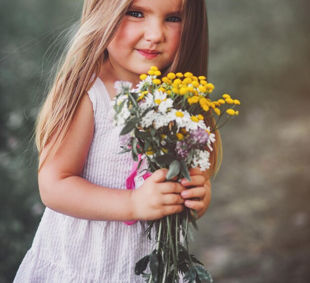 Happy little girl on the meadow in summer day