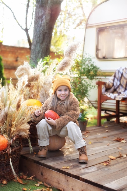 Happy little girl playing near home in fall garden