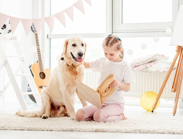 Happy little girl playing with a beautiful dog