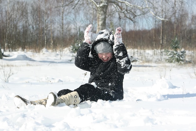 Happy little girl playing with snow outddors at winter in countryside