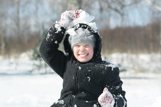 Happy little girl playing with snow outddors at winter in countryside