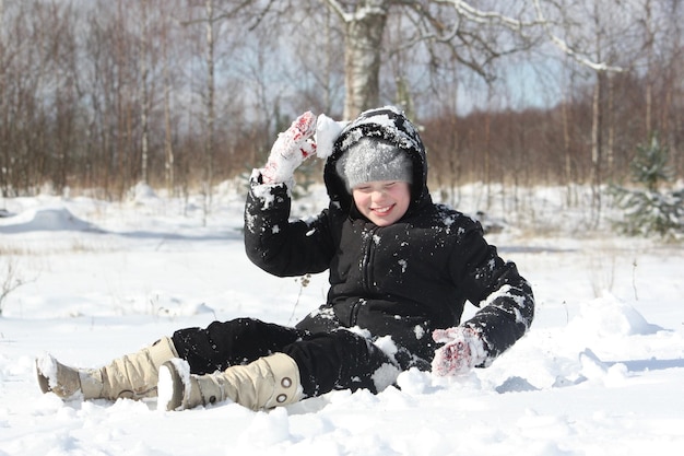 Happy little girl playing with snow outddors at winter in countryside