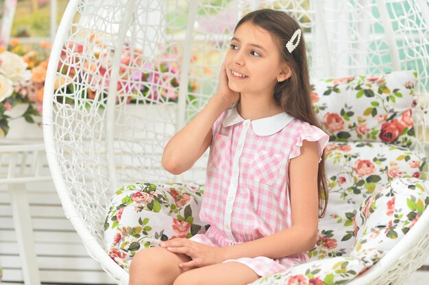 Happy little girl posing on swing