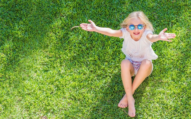 Bambina felice che riposa sull'erba