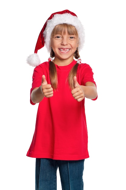 Happy little girl in Santa hat with thumbs up isolated on white background