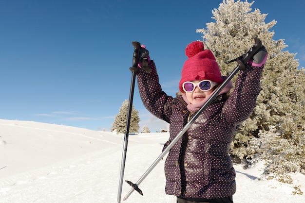 Happy little girl skiing downhill