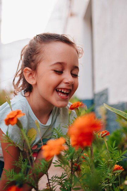 Foto bambina felice che sente l'odore dei fiori in estate