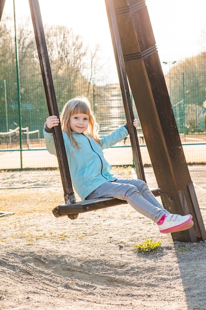 Happy little girl on the swing copy space