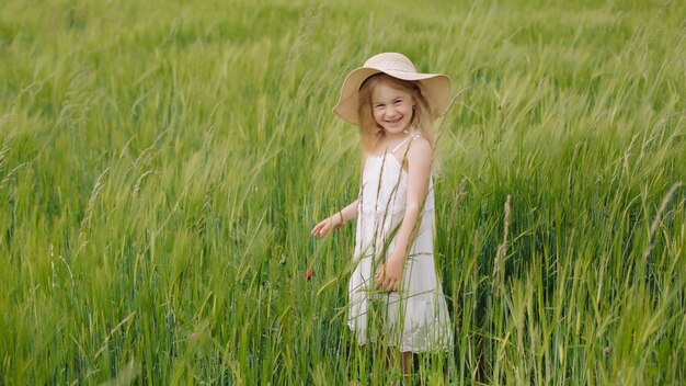 夏の晴れた日に芝生の上を歩く幸せな少女