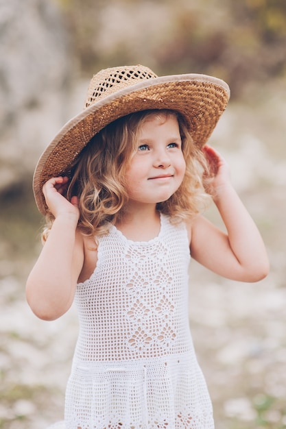 happy little girl wearing a hat outdoors