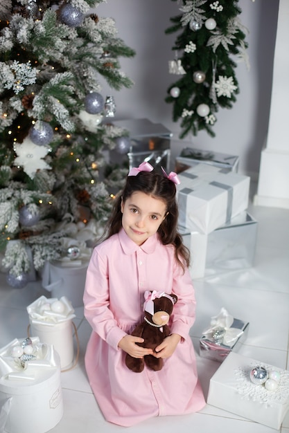 Счастливая маленькая девочка с рождественскими подарками дома