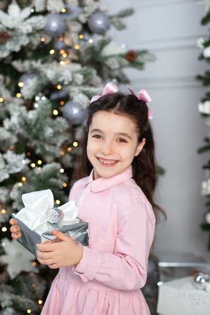 Happy little girl with christmas present at home