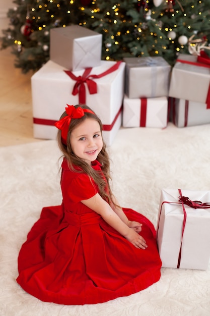 Happy little girl with christmas present at home