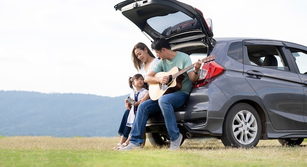 happy little girl with family sitting in the car