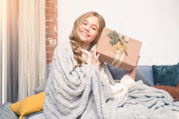 Foto bambina felice con il regalo nelle mani che sognano