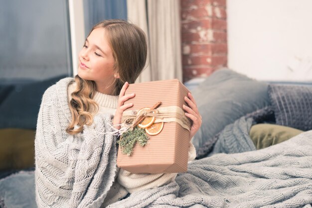 Foto bambina felice con il regalo nelle mani che sognano