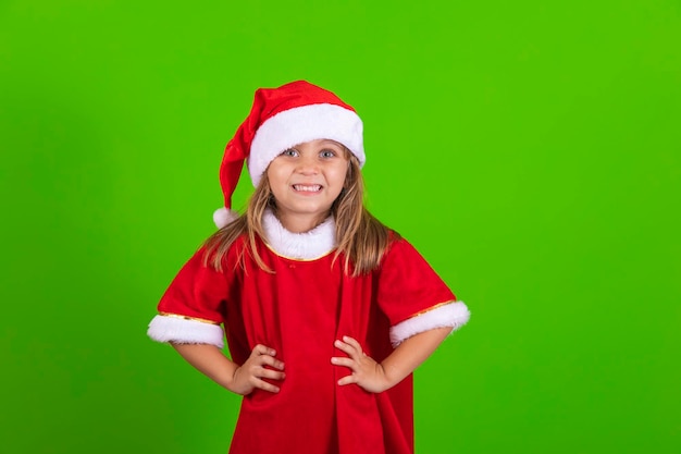 Happy little girl with Santa hat on green background Cute girl dressed for christmas smiling