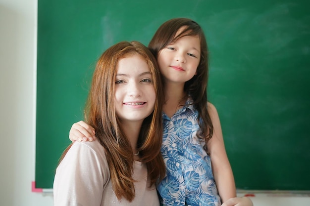 Happy little Girls against Chalkboard With Back To School