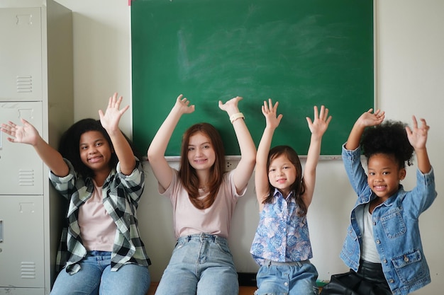 Фото Счастливые маленькие девочки против классной доски со спиной в школу