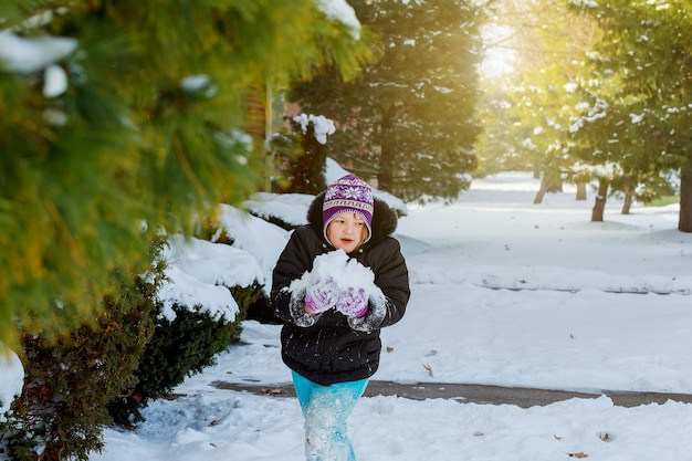 Photo happy little kid is playing in snow, good winter weather