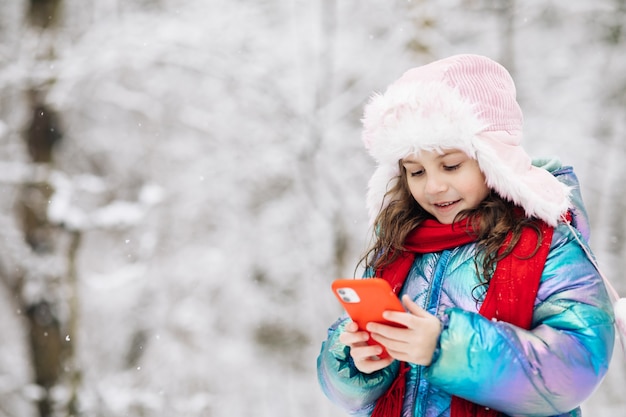 Happy little kid use smartphone funny face mask app look at cell screen smiles at something funny.