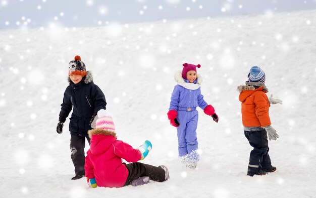Счастливые маленькие дети играют на открытом воздухе зимой