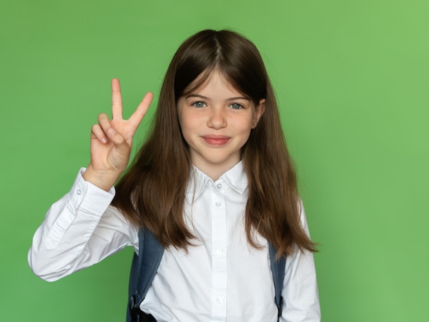 happy little school girl showing sign v, back to school concept