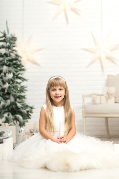 Happy little smiling girl with christmas gift box.